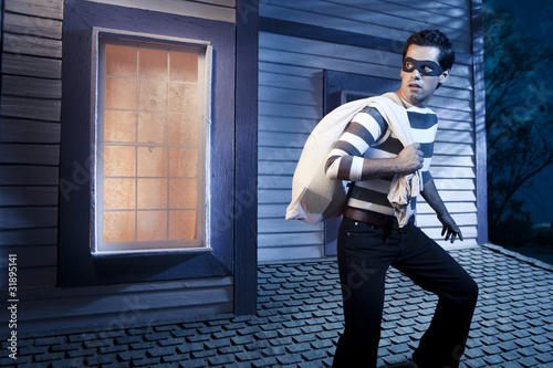 Photo: Thief walking on the roof of a house at night Thief walking on the roof of a house at night