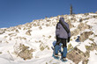 Climber in snowshoes (snow shoes) walking at the mountain slope