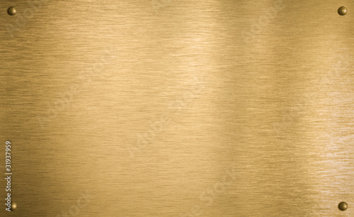 Photo: Brass or gold metal plate with four rivets Brass or gold metal plate with four rivets