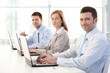 Young businesspeople working on laptop smiling