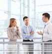 Businesspeople chatting in modern office lobby Businesspeople chatting in modern office lobby