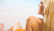 Young happy beautiful woman lying on sea beach