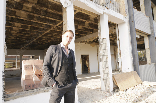 Photo: Mann auf der Baustelle vor der Fassade Mann auf der Baustelle vor der Fassade