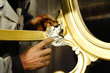 Hands working on wood gilding
