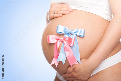 Photo: Beautiful young pregnant woman with ribbon. Isolated Beautiful young pregnant woman with ribbon. Isolated