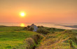 Irish cottage house near ocean at sunset Irish cottage house near ocean at sunset