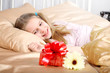 beautiful ten years' girl has seen in bed a gift on birthday.