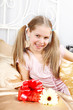beautiful ten years' girl has seen in bed a gift on birthday.