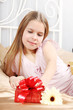 beautiful ten years' girl has seen in bed a gift on birthday.