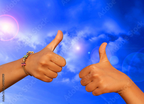 Photo: Woman's hand close-up shows a gesture ok against the blue sky Woman's hand close-up shows a gesture ok against the blue sky