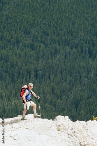 Photo: Man Hiking On A Ridge Overlooking A Forest Man Hiking On A Ridge Overlooking A Forest