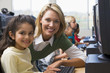 Teacher helping kindergarten children learn how to use computers