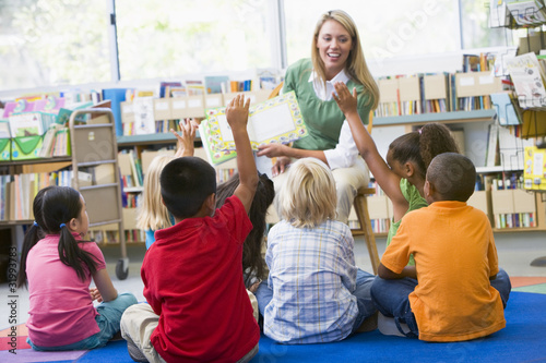 Photo: Kindergarten teacher reading to children in library Kindergarten teacher reading to children in library
