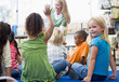 Kindergarten teacher reading to children in library, girl lookin