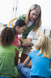 Kindergarten teacher showing bird's nest to children