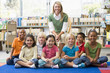 Foto: Kindergarten teacher sitting with children in library Kindergarten teacher sitting with children in library