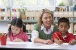 Kindergarten teacher helping students with writing skills