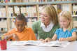 Kindergarten teacher helping students with reading skills