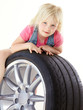 Foto: Cute blond girl playing with a summer tyre Cute blond girl playing with a summer tyre