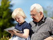 Foto: Old grandfather and little girl using touchpad e-book readers Old grandfather and little girl using touchpad e-book readers