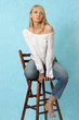 Sexy girl sits on a wooden chair.