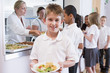 Foto: Schoolboy holding plate of lunch in school cafeteria Schoolboy holding plate of lunch in school cafeteria