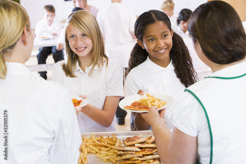 Photo: Lunchladies serving plates of lunch in school cafeteria Lunchladies serving plates of lunch in school cafeteria