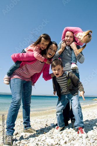 Photo: Happy family having fun by the sea Happy family having fun by the sea