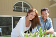 Young couple sitting in front of their new house
