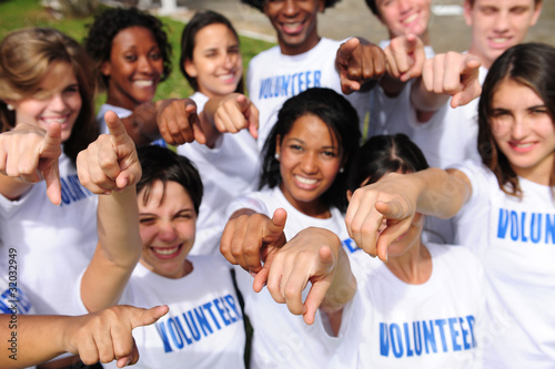 Photo: happy volunteer group pointing towards camera happy volunteer group pointing towards camera