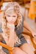 Young woman sits in beautiful armchair