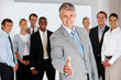Happy mature businessman welcoming you at his office