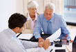 Male consultant advising couple with financial papers