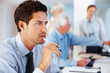 Thoughtful young businessman sitting at office