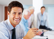 Cheerful young businessman working at office