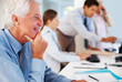 Old businessman working happily in office