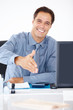Business executive sitting at a desk and offering handshake