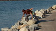 Young couple climbing on rocks overlooking the water