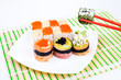 sushi on plate with two red sticks