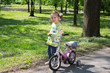 little girl with bicycle posing in park