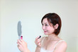口紅を塗っている笑顔の女性