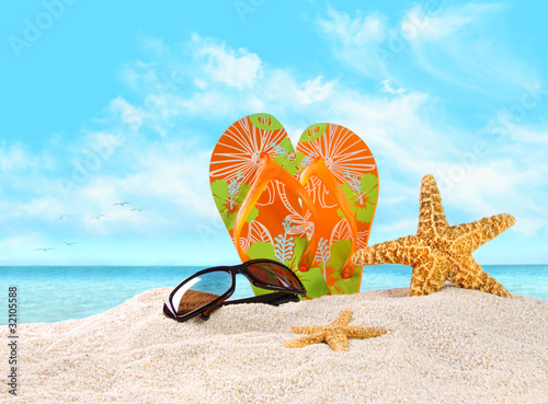 Photo: Flip- flops in the sand with starfish Flip- flops in the sand with starfish