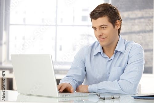 Photo: Young businessman working in office Young businessman working in office