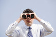 Young business man looking through binocular Young business man looking through binocular