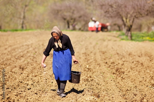 Photo: Senior woman farmer sowing Senior woman farmer sowing