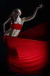 The girl in a red dress against a dark background