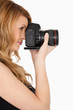 Lovely blond-haired woman taking a photo with a camera Lovely blond-haired woman taking a photo with a camera
