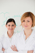 Cute women in front of a white board in a lab