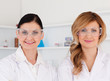 Two female scientists with safety glasses looking at the camera
