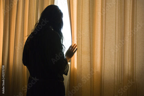 Photo: depressed woman by window depressed woman by window